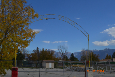 Image of metal sign that says Kearns American located at entrance to ballfield.  