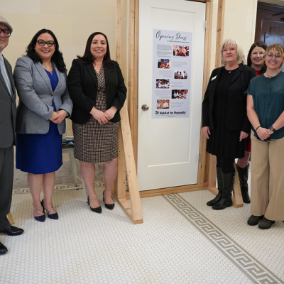 Image of people standing around a door. 